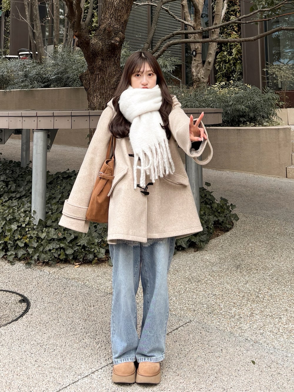 ブルー系のデニムパンツ、ベージュ系のその他アウター、ベージュ系のブーツを着用したレディースの冬コーディネートの2枚目の写真