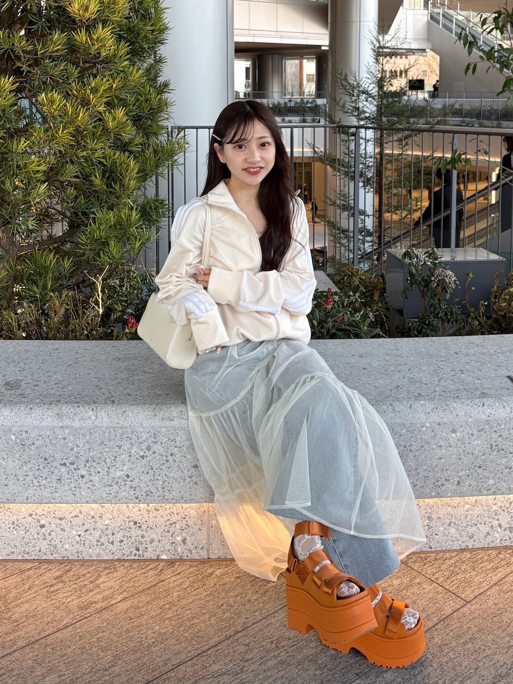 ホワイト系のスカート、オレンジ系のサンダル、ホワイト系のジャージを着用したレディースの春コーディネートの4枚目の写真