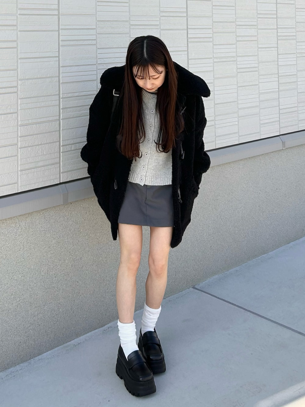 グレー系のカーディガン/ボレロ、グレー系のスカート、ブラック系のショルダーバッグを着用したレディースの冬コーディネートの4枚目の写真