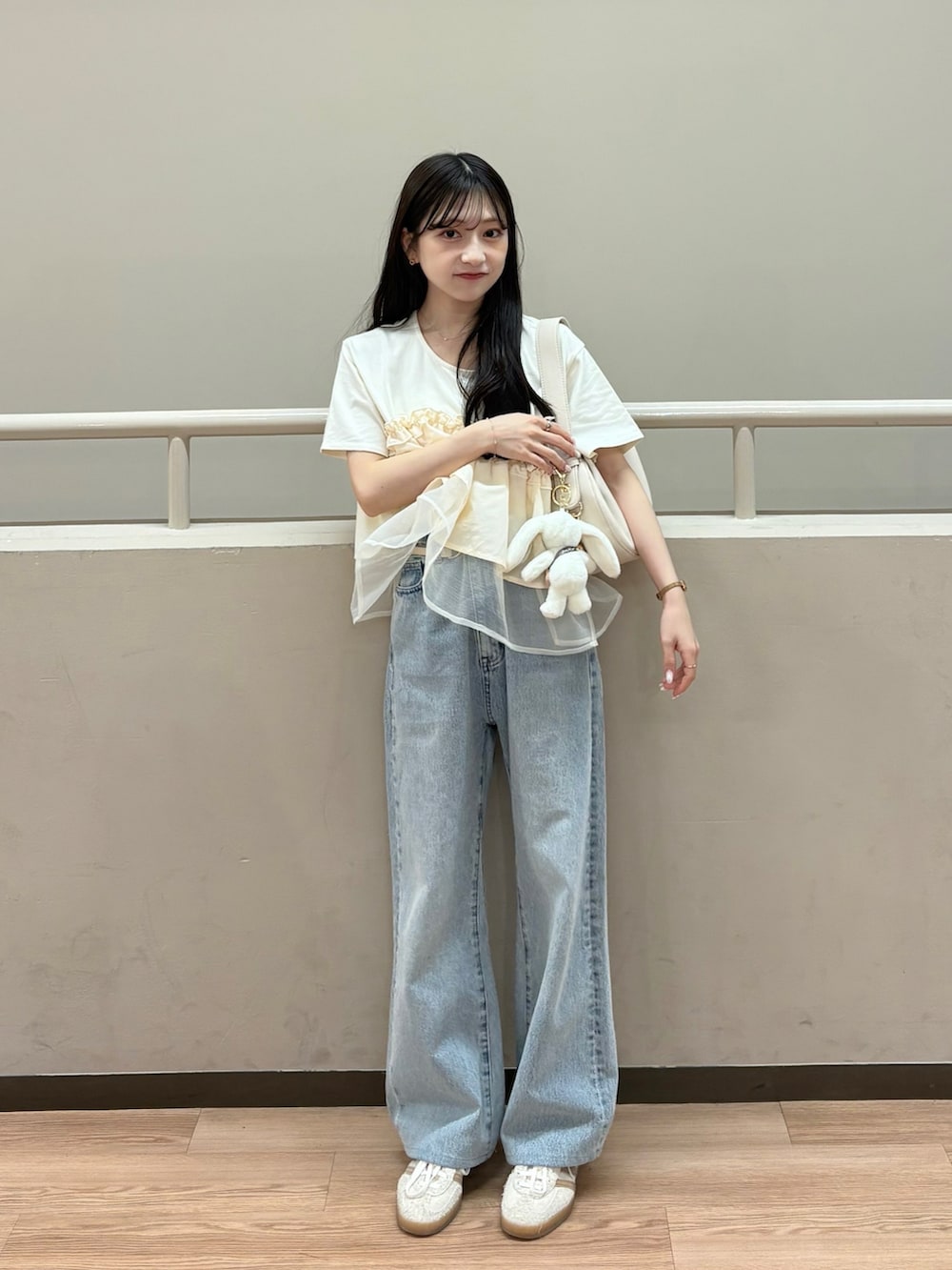 ベージュ系のTシャツ/カットソー、ベージュ系のハンドバッグ、ホワイト系のスニーカーを着用したレディースの夏コーディネートの4枚目の写真