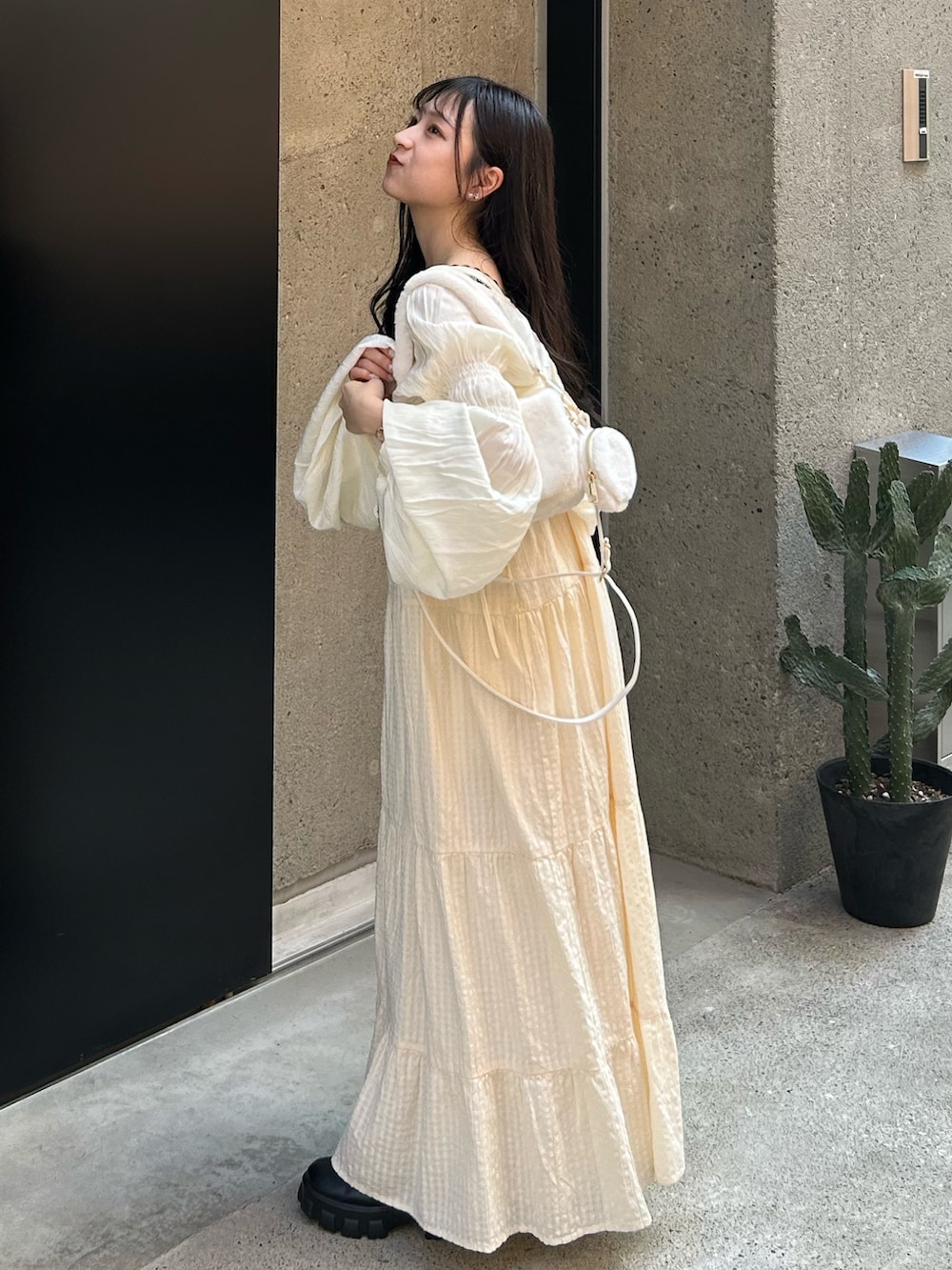 ホワイト系のワンピース/ドレス、ホワイト系のカーディガン/ボレロ、ホワイト系のショルダーバッグを着用したレディースの秋コーディネートの2枚目の写真