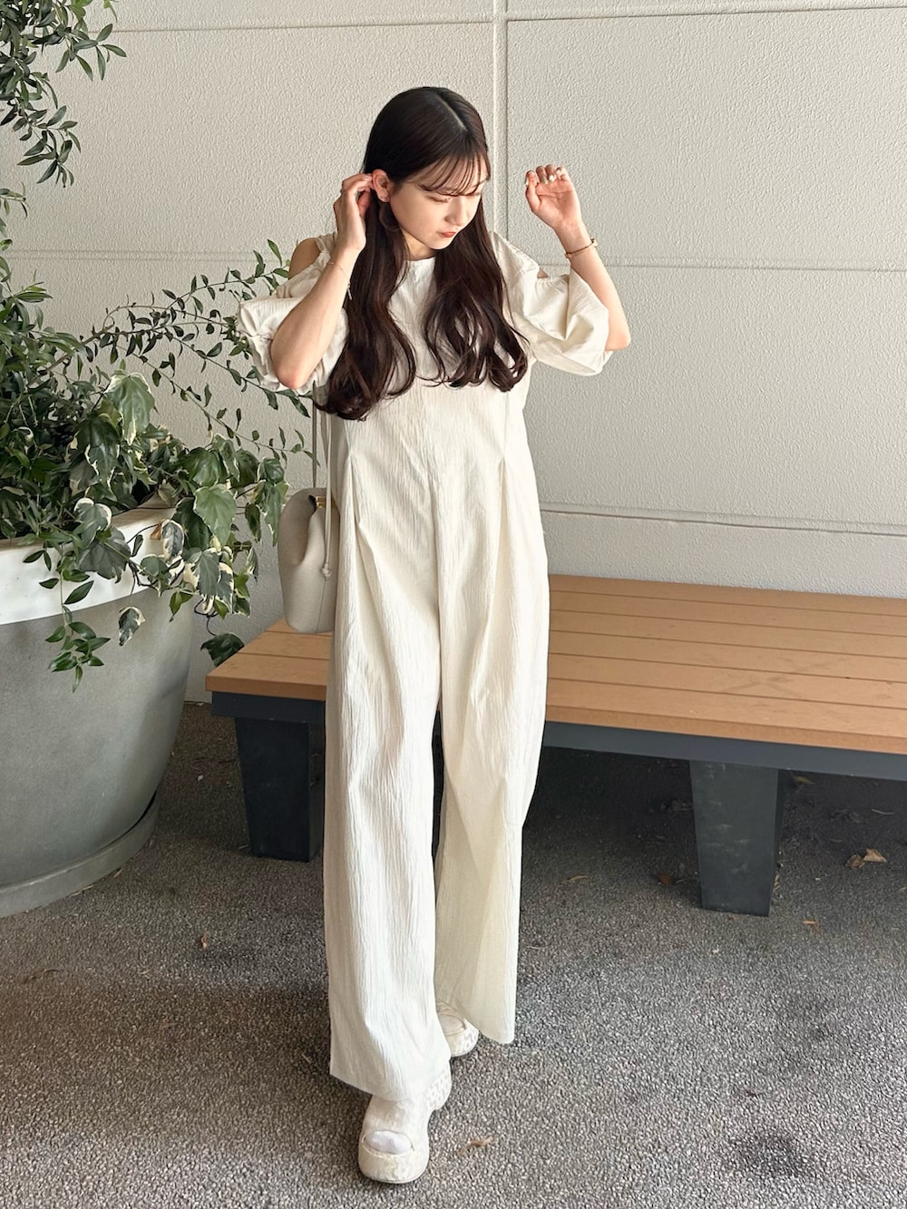 ホワイト系のつなぎ/オールインワン、ベージュ系のバッグ、ホワイト系のサンダルを着用したレディースの春コーディネートの3枚目の写真