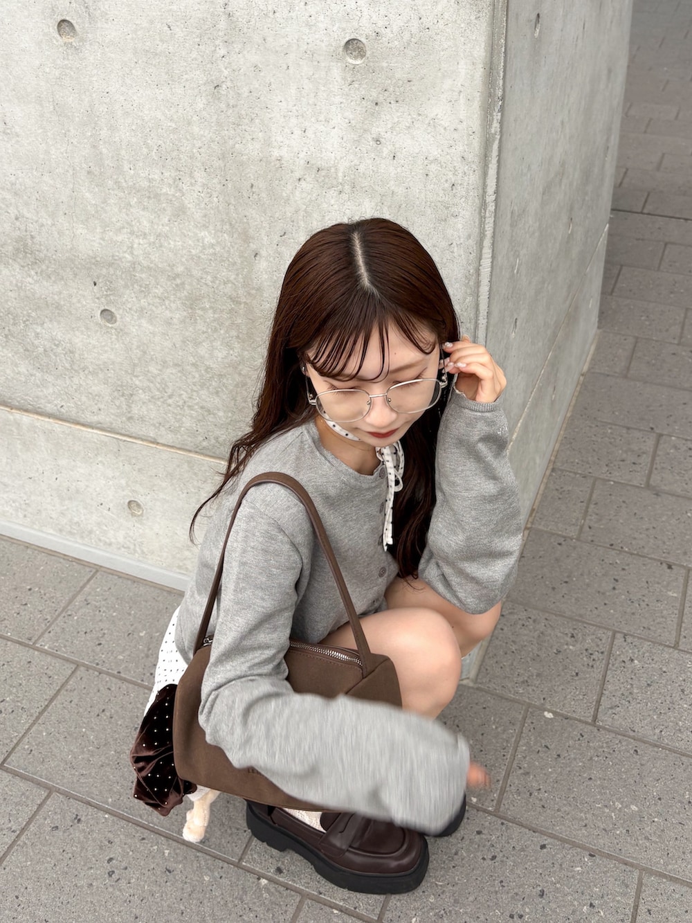 ホワイト系のTシャツ/カットソー、グレー系のカーディガン/ボレロ、ブラウン系のローファーを着用したレディースの秋コーディネートの2枚目の写真