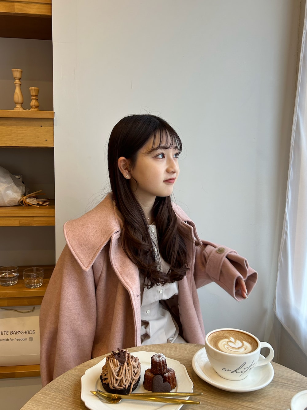 ホワイト系のワンピース、ホワイト系のショルダーバッグ、ピンク系のジャケット/アウターを着用したレディースの冬コーディネートの3枚目の写真