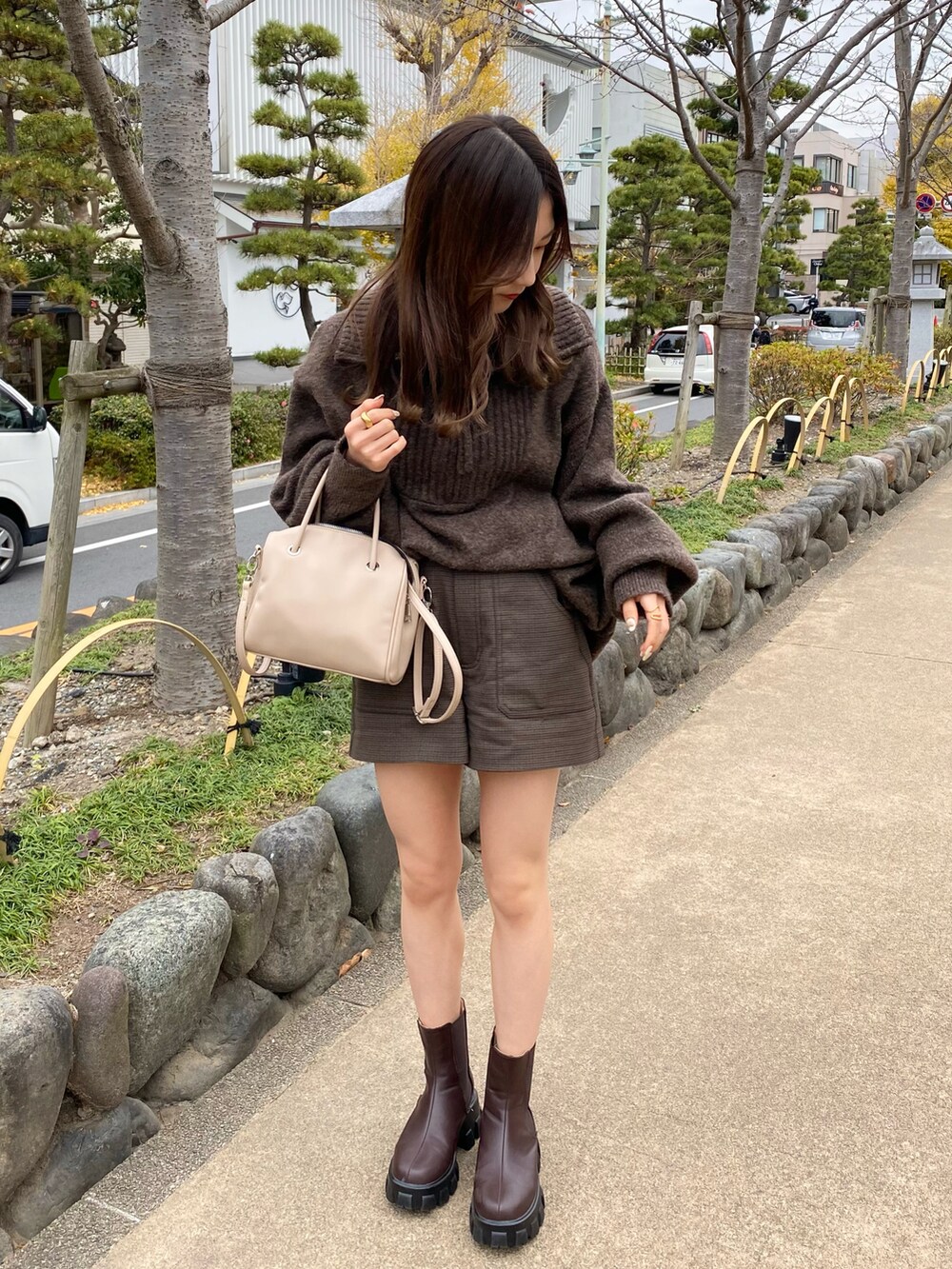 ホワイト系のダウンジャケット/コート、ブラウン系のブーツ、ベージュ系のバッグを着用したレディースの冬コーディネートの3枚目の写真