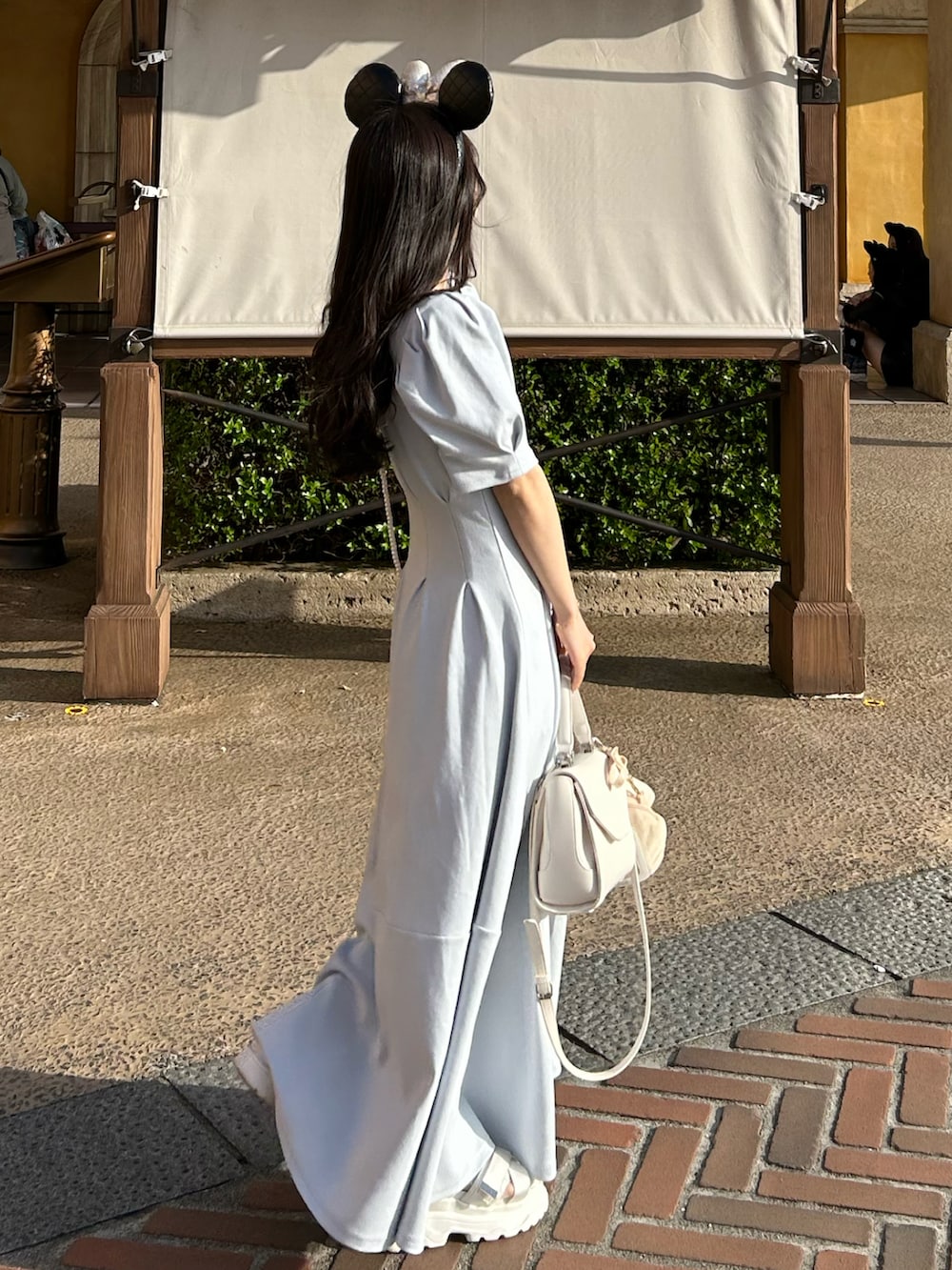 ホワイト系のショルダーバッグ、ホワイト系のシャツ/ブラウス、ブルー系のワンピースを着用したレディースの春コーディネートの2枚目の写真