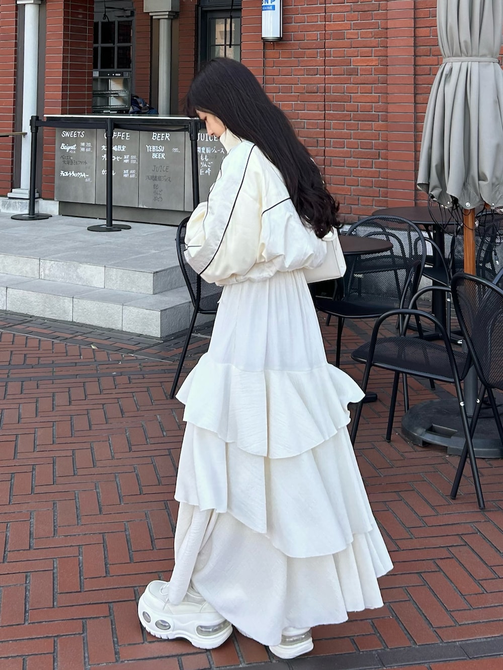 ホワイト系のワンピース/ドレス、ホワイト系のスニーカー、ホワイト系のブルゾンを着用したレディースの春コーディネートの2枚目の写真