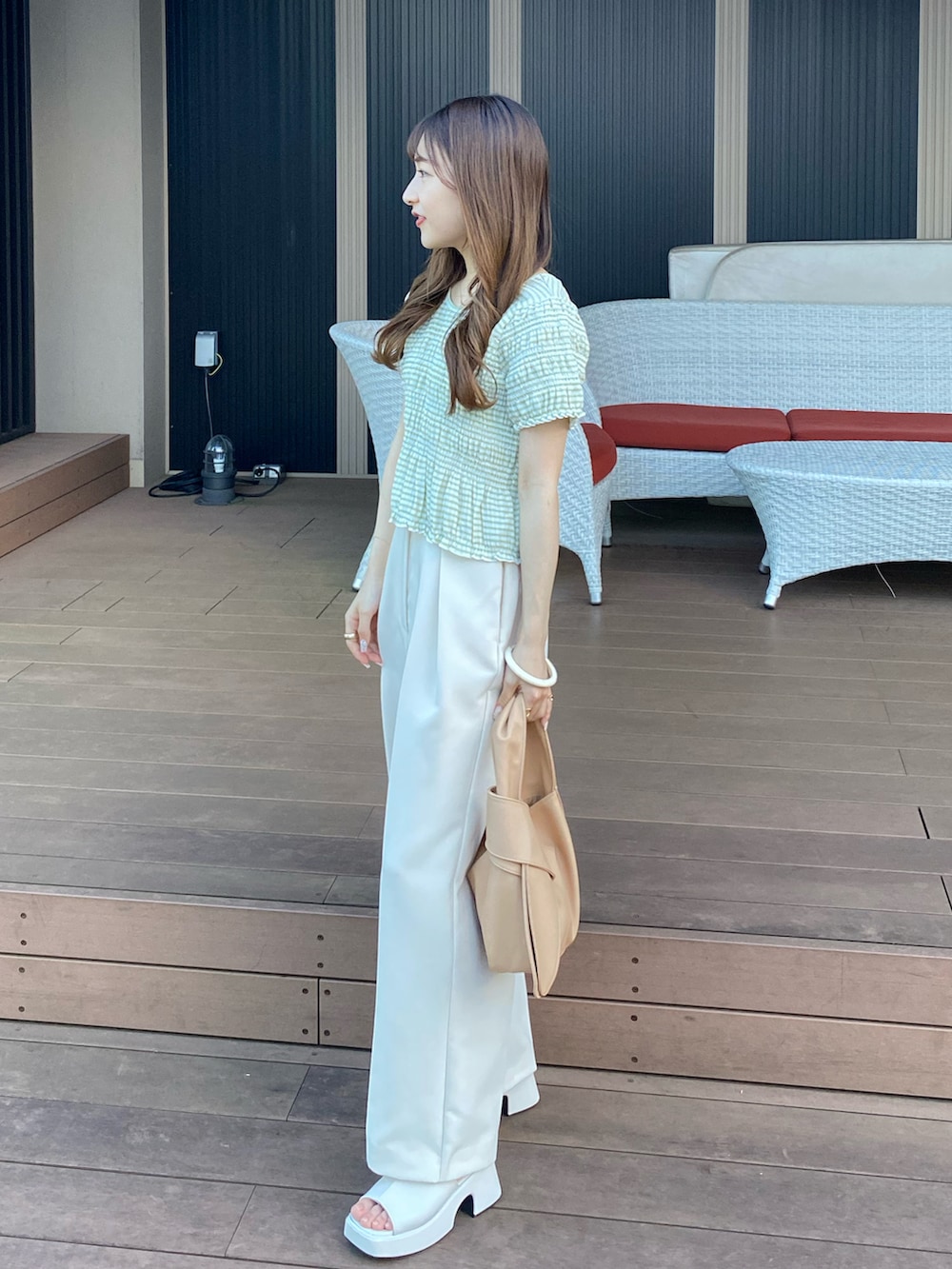 ベージュ系のバッグ、グリーン系のTシャツ/カットソー、ホワイト系のその他パンツを着用したレディースの夏コーディネートの2枚目の写真