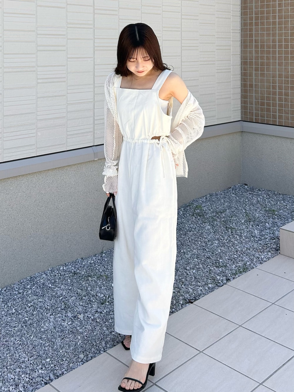 ブラック系のバッグ、ホワイト系のサロペット/オーバーオール、ホワイト系のTシャツ/カットソーを着用したレディースの春コーディネートの3枚目の写真