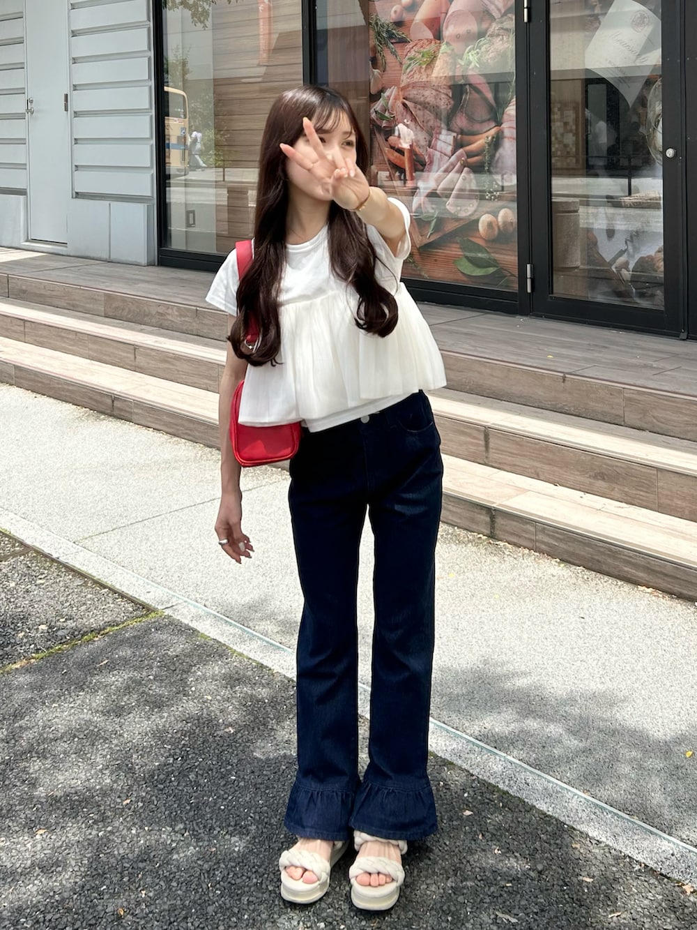 ブルー系のデニムパンツ、レッド系のショルダーバッグ、ホワイト系のTシャツ/カットソーを着用したレディースの夏コーディネートの3枚目の写真