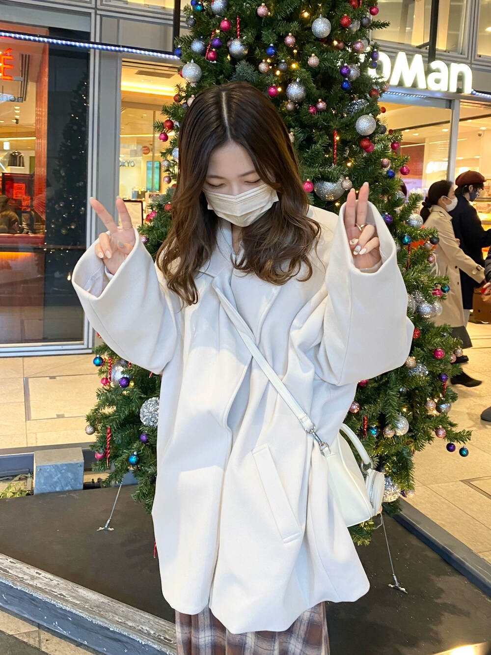 ブラウン系のスカート、ホワイト系のジャケット/アウター、ホワイト系のスウェットを着用したレディースの冬コーディネートの3枚目の写真