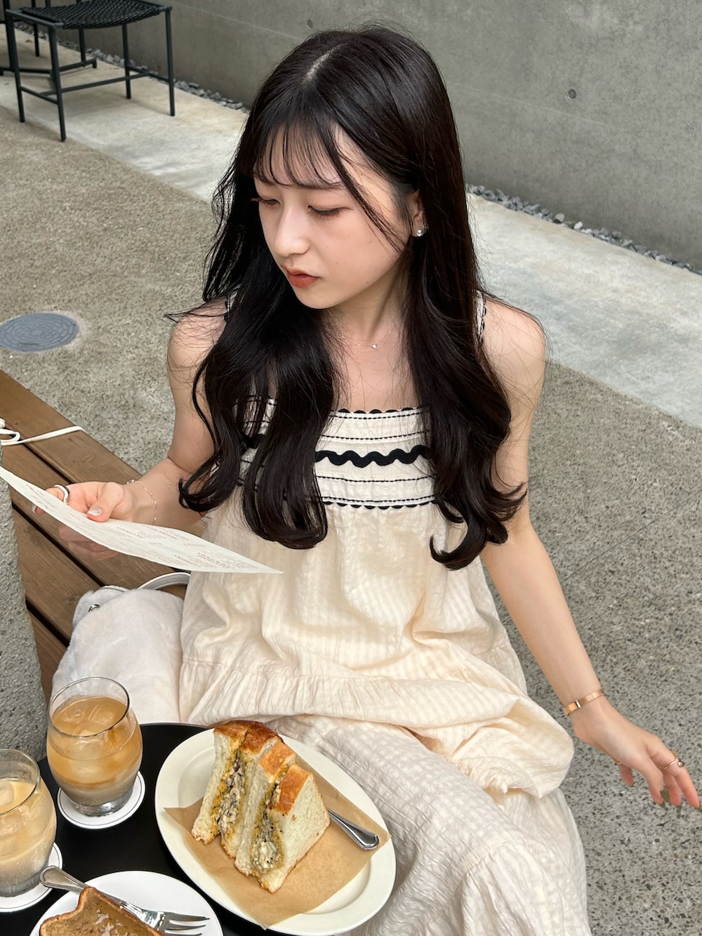 ホワイト系のワンピース/ドレス、ホワイト系のカーディガン/ボレロ、ホワイト系のショルダーバッグを着用したレディースの秋コーディネートの3枚目の写真