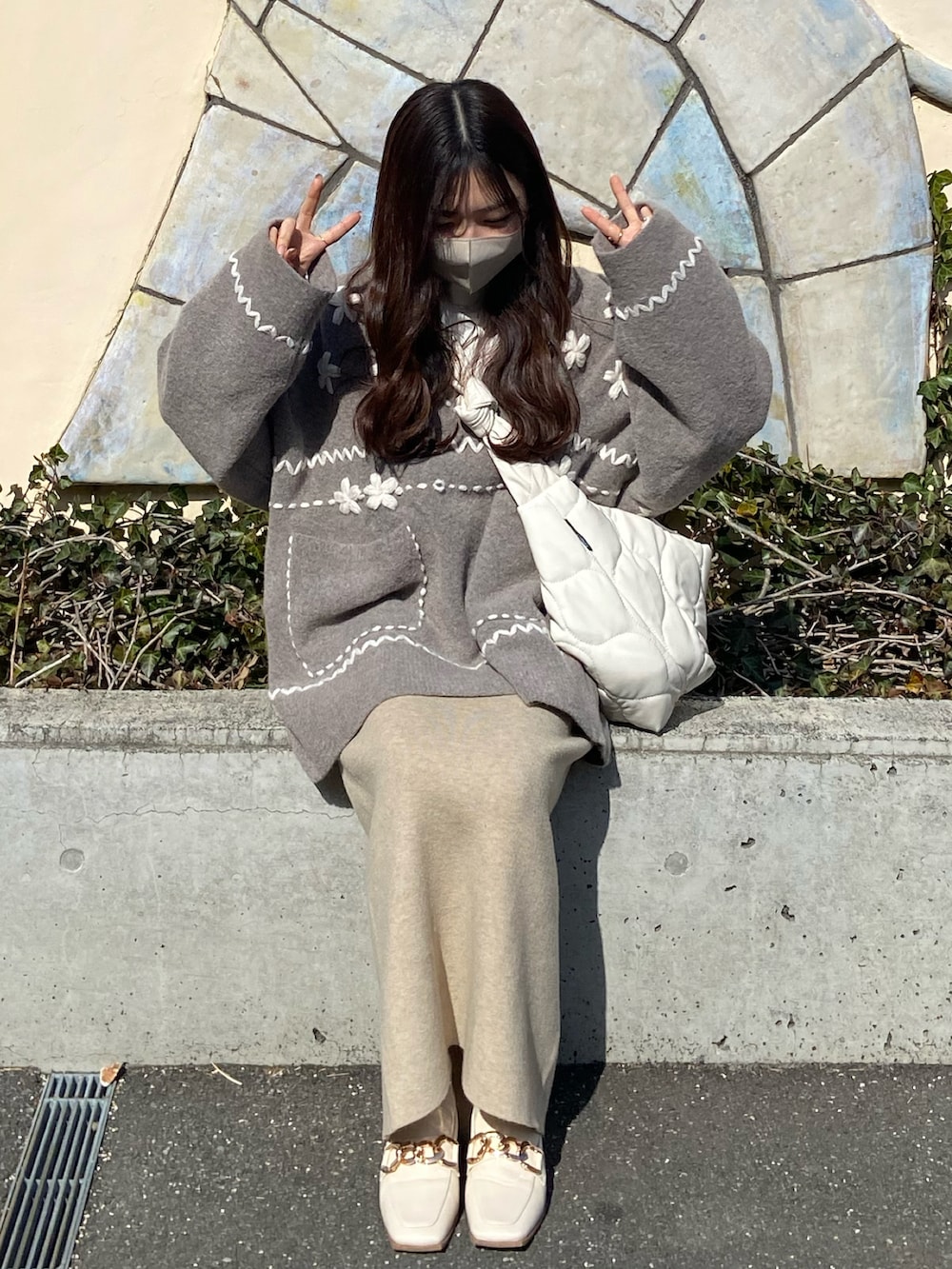 ホワイト系のローファー、ベージュ系のニット/セーター、ホワイト系のショルダーバッグを着用したレディースの冬コーディネートの2枚目の写真