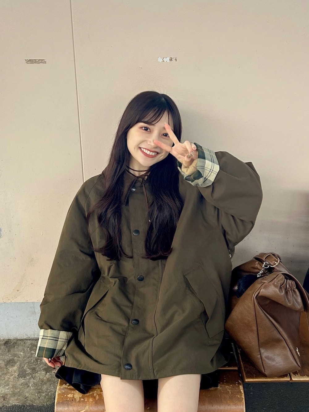 ベージュ系のニット/セーター、ブラウン系のショルダーバッグ、ブラウン系のブーツを着用したレディースの秋コーディネートの4枚目の写真