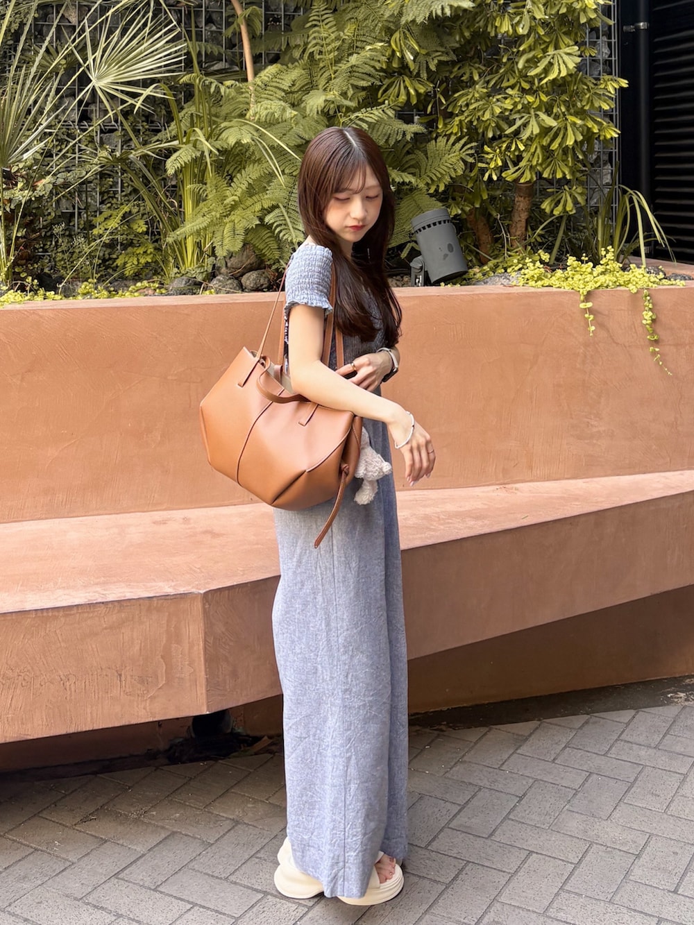 ホワイト系のサンダル、グレー系のサロペット/オーバーオール、ブラウン系のバッグを着用したレディースの夏コーディネートの3枚目の写真