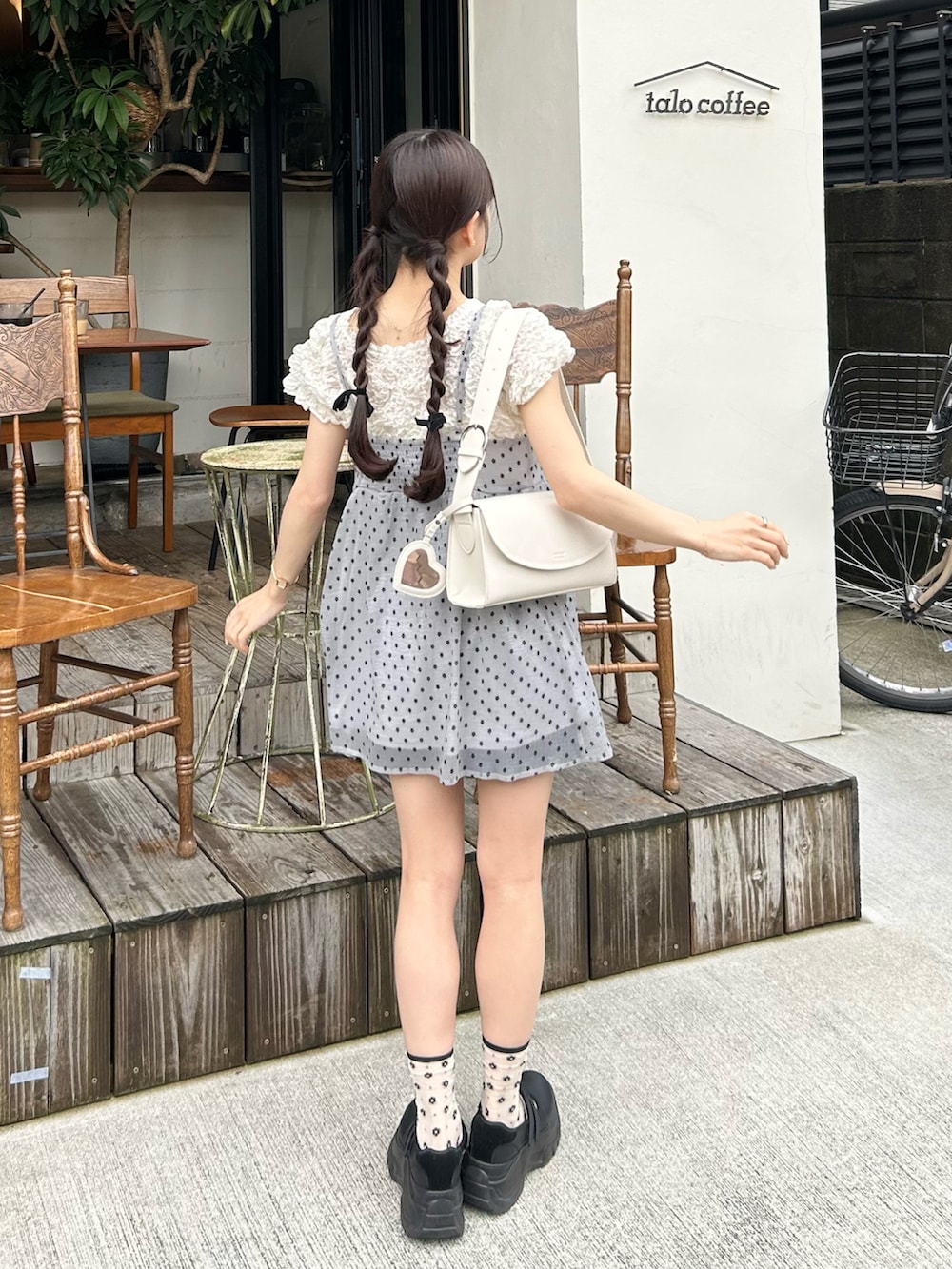 グレー系のカーディガン/ボレロ、ホワイト系のショルダーバッグ、ホワイト系のシャツ/ブラウスを着用したレディースの夏コーディネートの2枚目の写真