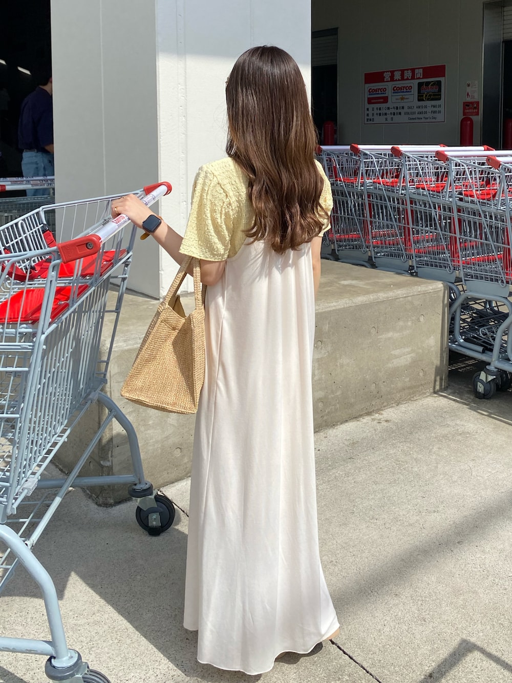 ベージュ系のトートバッグ、ホワイト系のワンピース、イエロー系のTシャツ/カットソーを着用したレディースの夏コーディネートの2枚目の写真