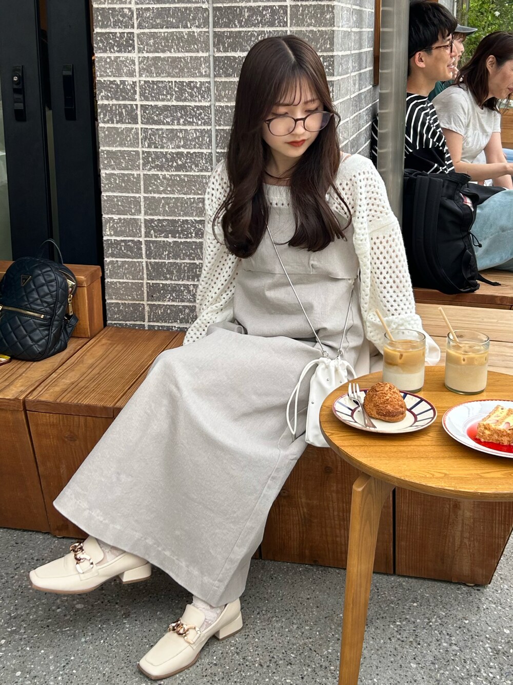 グレー系のワンピース、ホワイト系のショルダーバッグ、ホワイト系のローファーを着用したレディースの春コーディネートの4枚目の写真