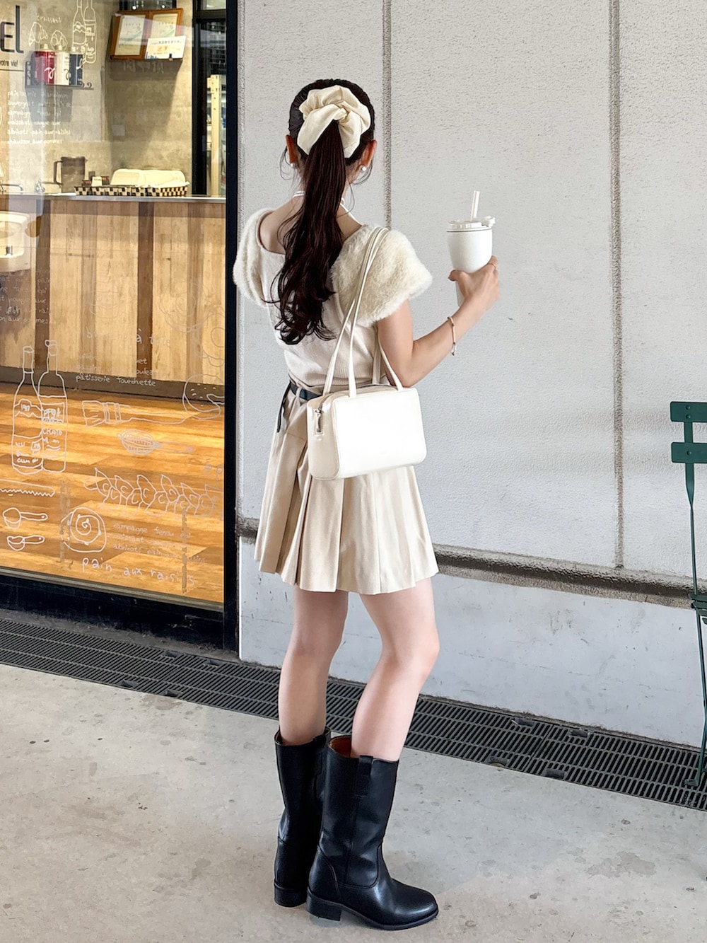 ベージュ系のその他パンツ、ブラック系のブーツ、ホワイト系のショルダーバッグを着用したレディースの秋コーディネートの3枚目の写真