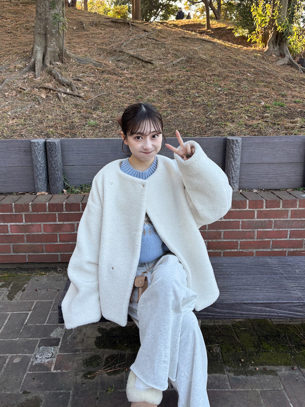 グレー系のスウェットパンツ、ホワイト系のブルゾン、ブルー系のニット/セーターを着用したレディースの冬コーディネートの5枚目の写真
