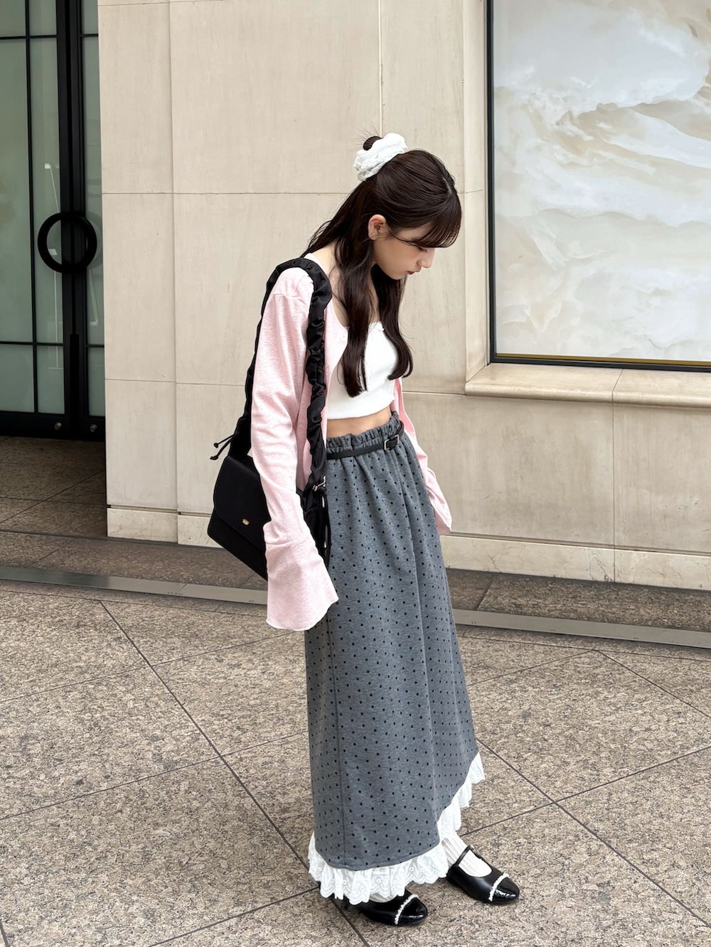 ブラック系のバッグ、ピンク系のカーディガン/ボレロ、ホワイト系のキャミソールを着用したレディースの夏コーディネートの2枚目の写真