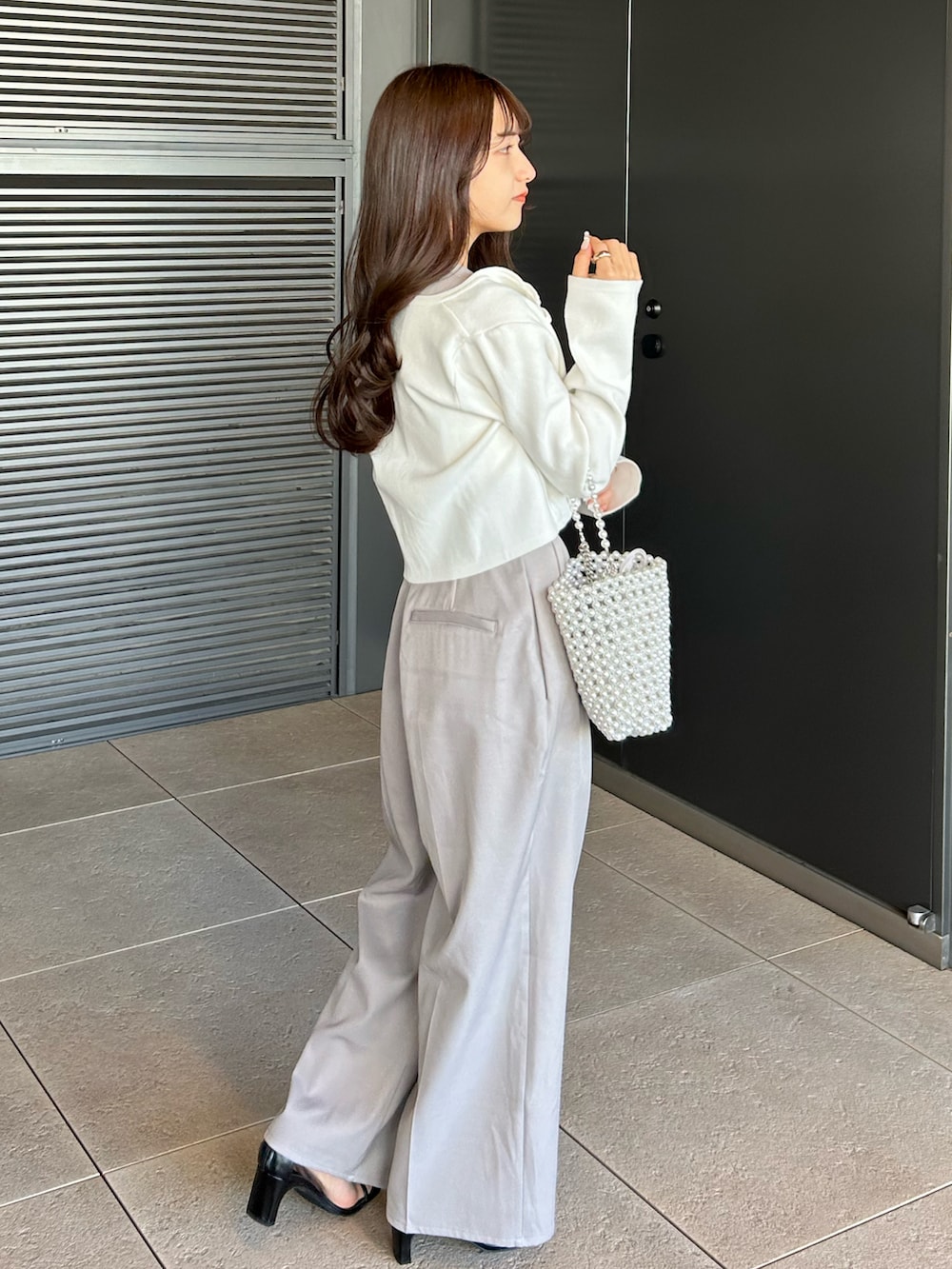 ホワイト系のキャミソール、グレー系のその他パンツ、シルバー系のバッグを着用したレディースの春コーディネートの3枚目の写真