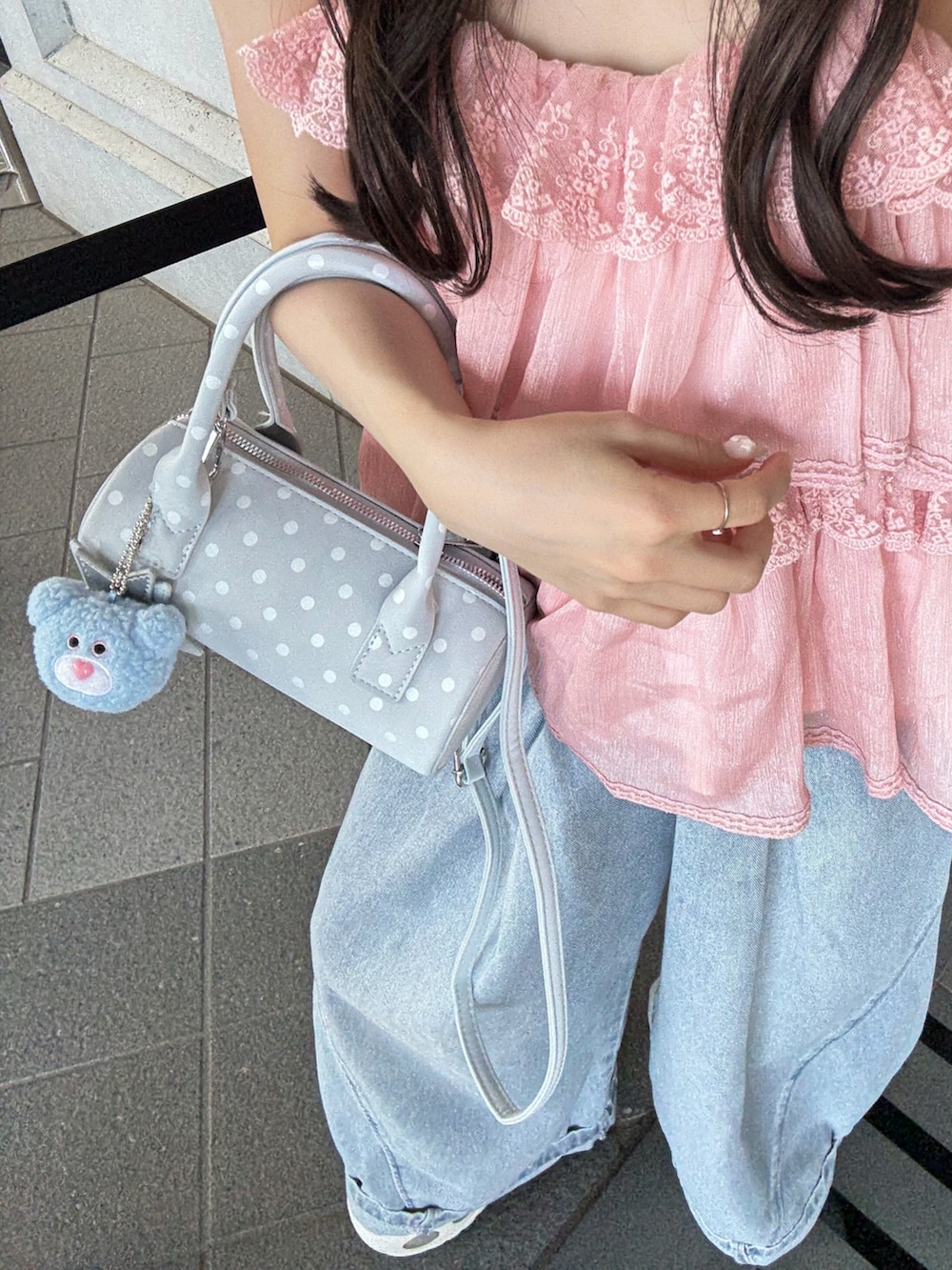 ブルー系のデニムパンツ、ホワイト系のトップス、ホワイト系のスニーカーを着用したレディースの夏コーディネートの4枚目の写真