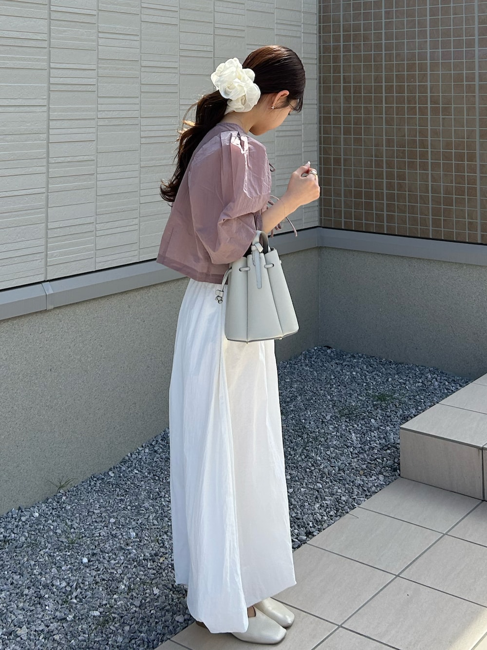 ホワイト系のバッグ、ピンク系のシャツ/ブラウス、ホワイト系のチューブトップを着用したレディースの春コーディネートの3枚目の写真