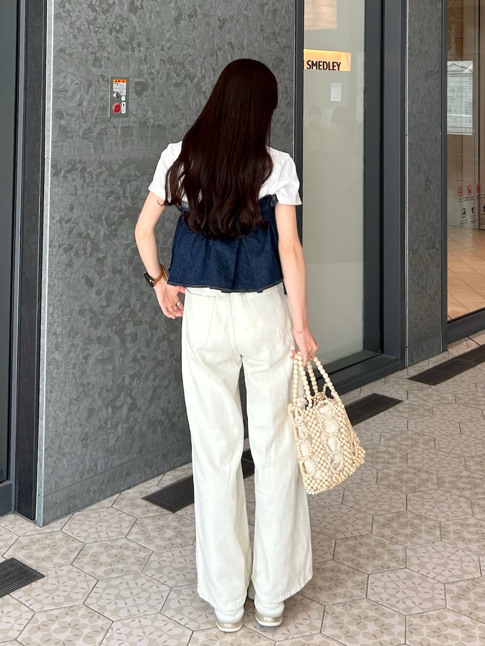 ホワイト系のハンドバッグ、ホワイト系のその他パンツ、ホワイト系のTシャツ/カットソーを着用したレディースの夏コーディネートの4枚目の写真