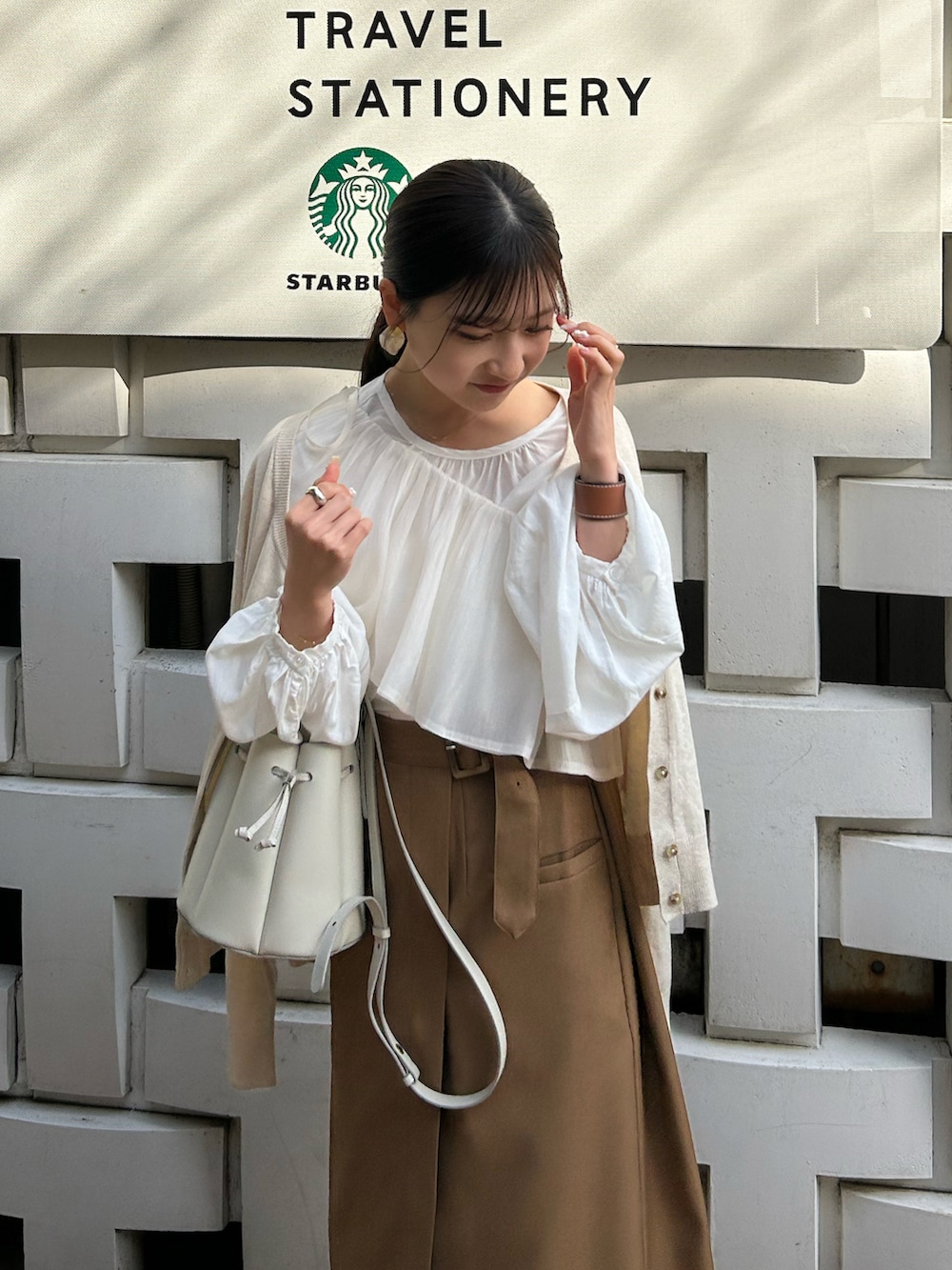 ホワイト系のシャツ/ブラウス、ブラウン系のスカート、ホワイト系のバッグを着用したレディースの春コーディネートの4枚目の写真