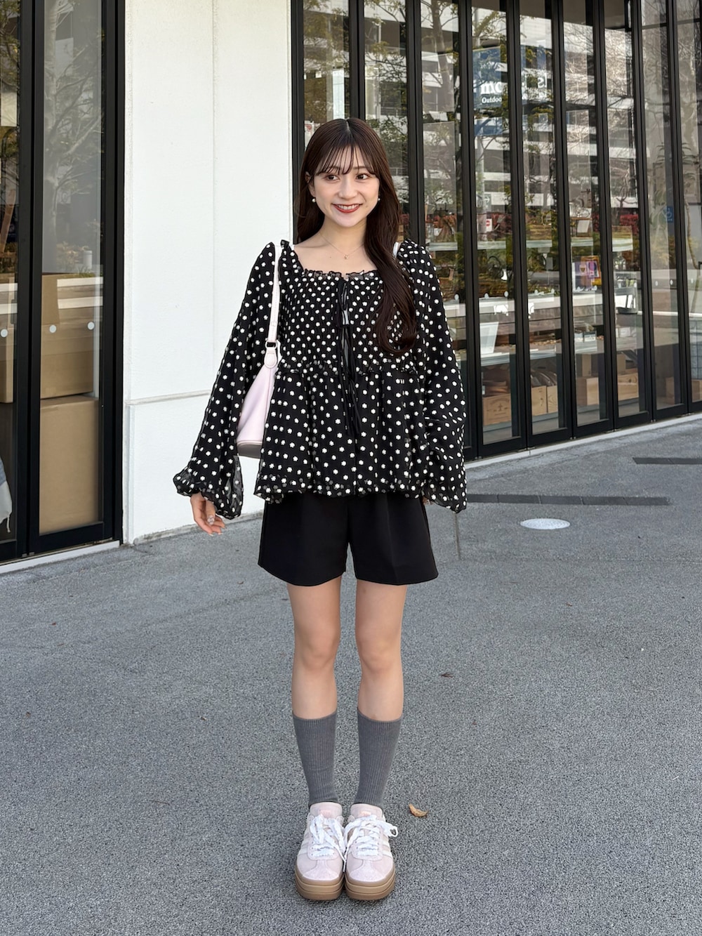 ピンク系のスニーカー、ブラック系のその他パンツ、ブラック系のシャツ/ブラウスを着用したレディースの春コーディネートの2枚目の写真