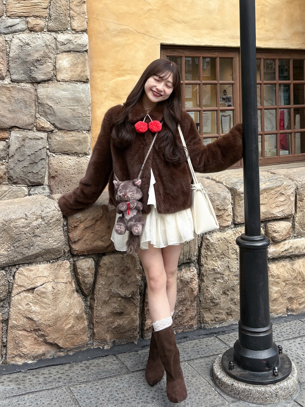 ブラウン系のブーツ、ホワイト系のワンピース、ブラウン系のジャケット/アウターを着用したレディースの春コーディネートの3枚目の写真