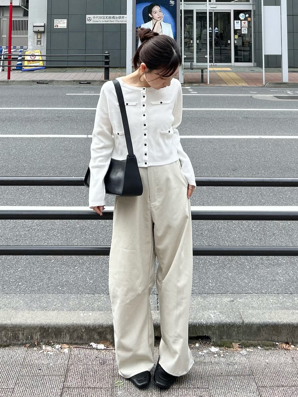 ホワイト系のスラックス、ホワイト系のカーディガン/ボレロ、ブラック系のトートバッグを着用したレディースの秋コーディネートの2枚目の写真