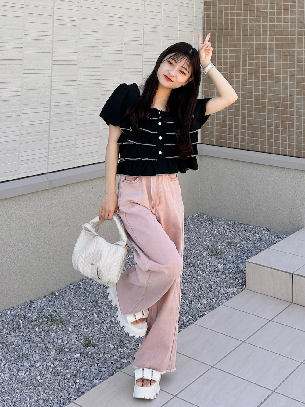 ピンク系のデニムパンツ、ホワイト系のショルダーバッグ、ホワイト系のサンダルを着用したレディースの夏コーディネートの3枚目の写真