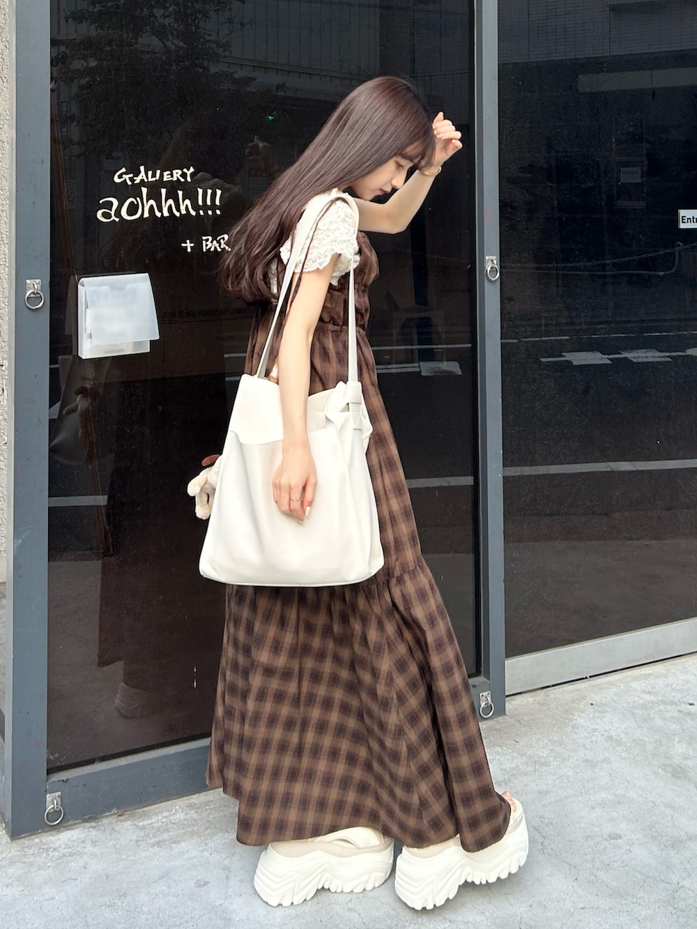 ブラウン系のワンピース、ホワイト系のトートバッグ、ホワイト系のサンダルを着用したレディースの夏コーディネートの2枚目の写真