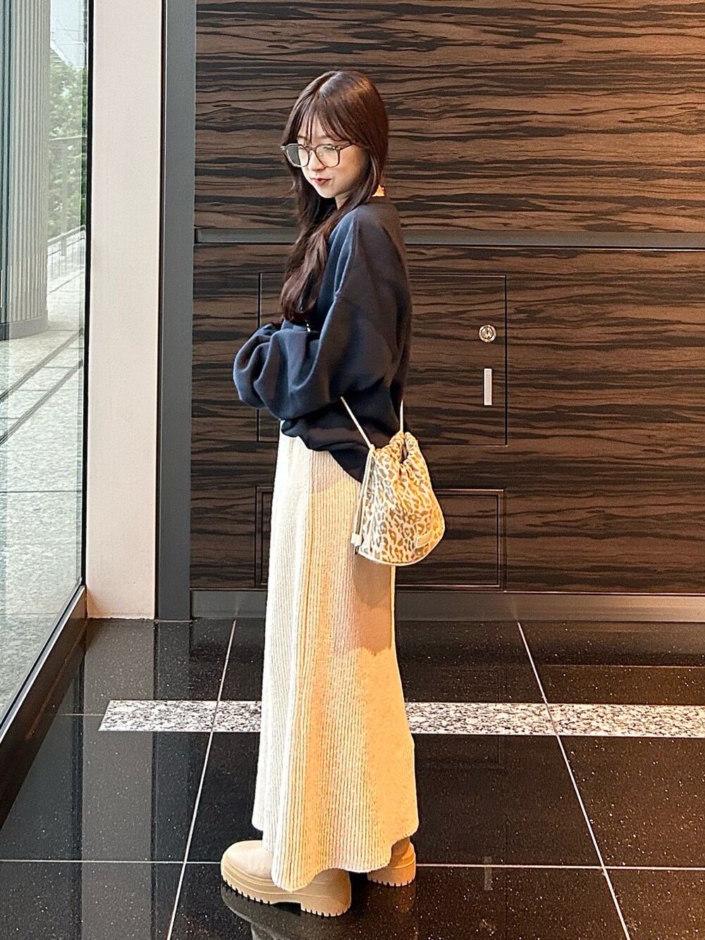 ホワイト系のスカート、ブルー系のスウェット、ベージュ系のショルダーバッグを着用したレディースの秋コーディネートの5枚目の写真