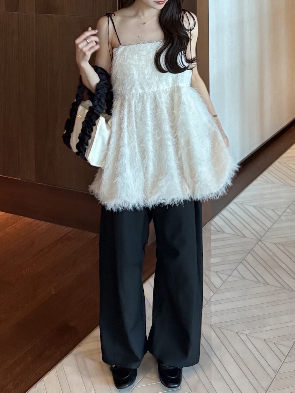 ホワイト系のキャミソール、ブラウン系のテーラードジャケット、ブラック系のスラックスを着用したレディースの秋コーディネートの3枚目の写真