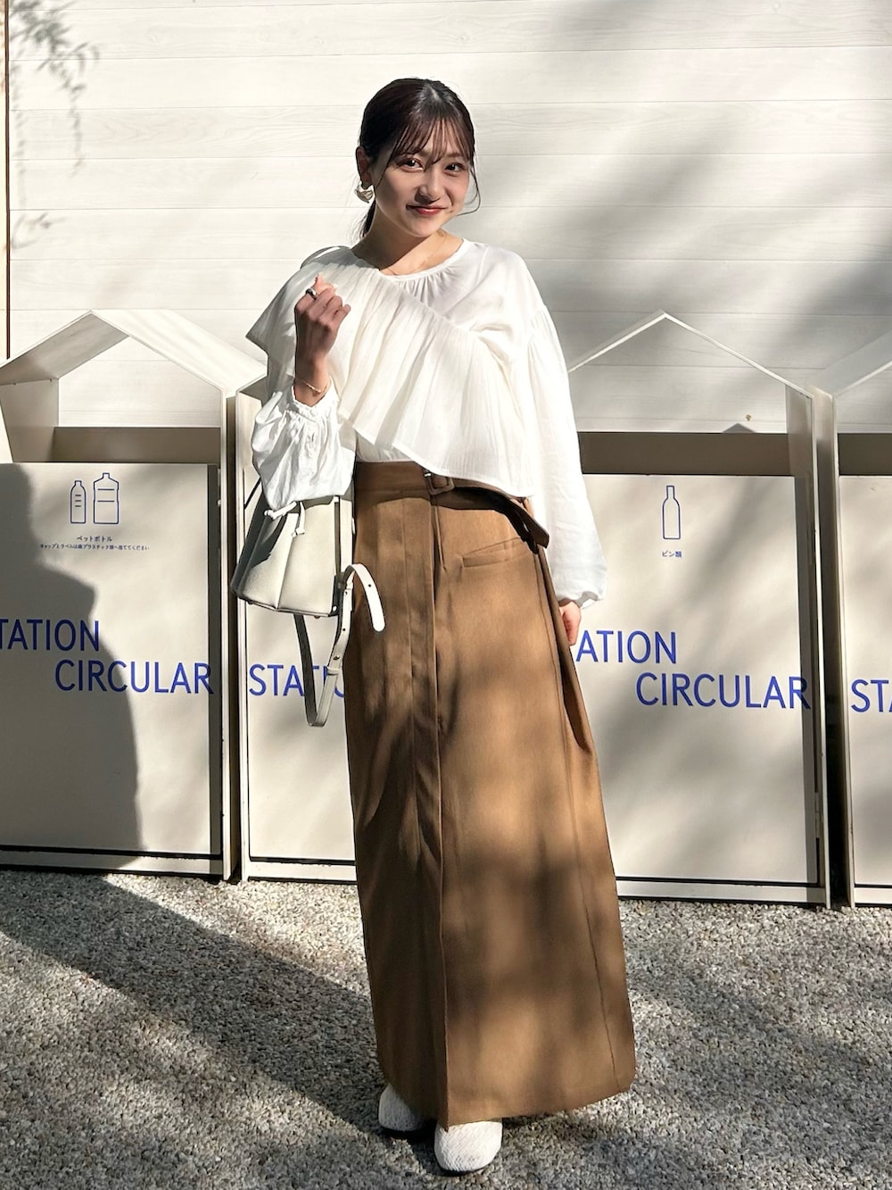 ホワイト系のシャツ/ブラウス、ブラウン系のスカート、ホワイト系のバッグを着用したレディースの春コーディネートの2枚目の写真