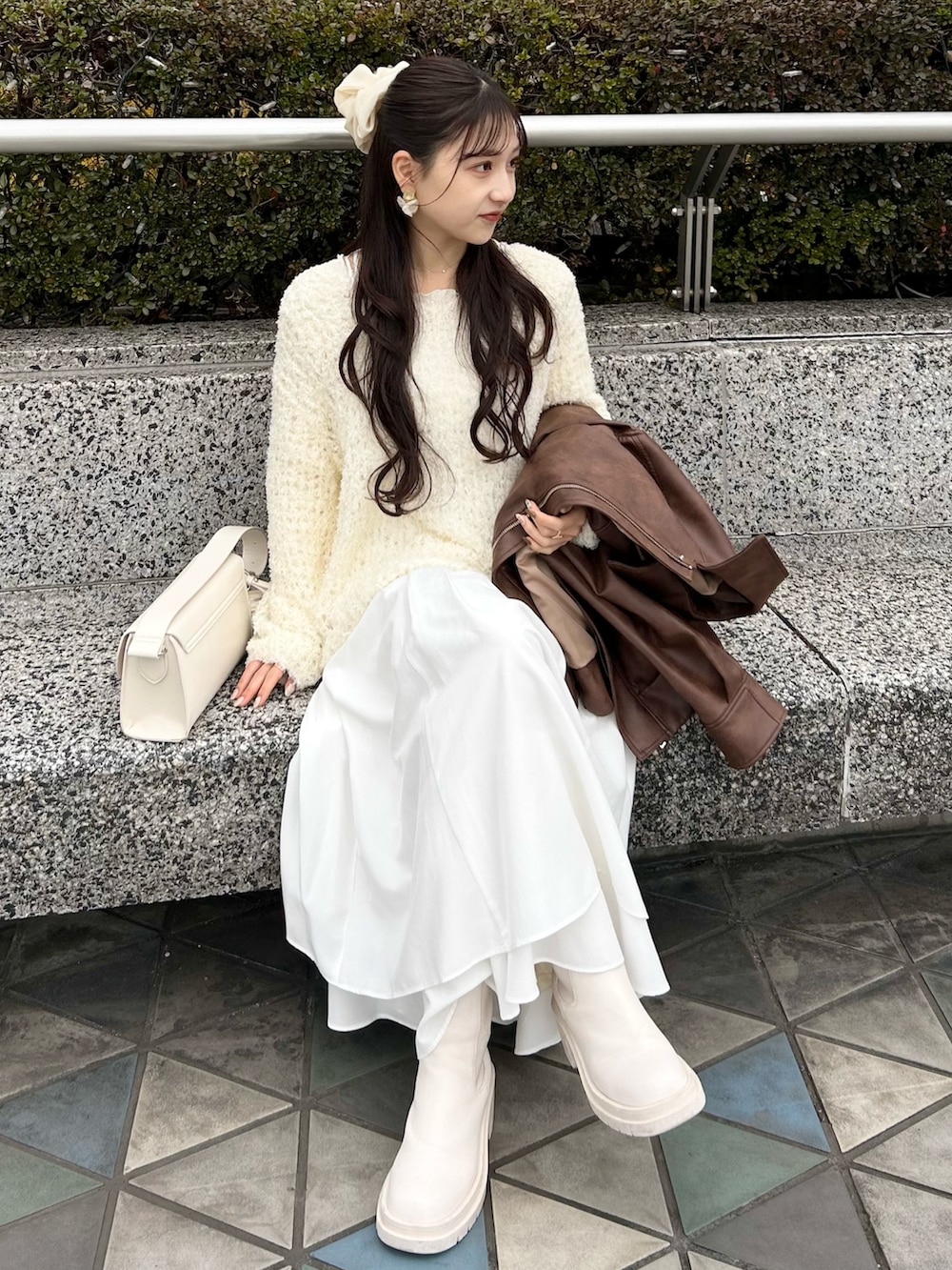 ブラウン系のブルゾン、ホワイト系のワンピース、ホワイト系のショルダーバッグを着用したレディースの春コーディネートの3枚目の写真