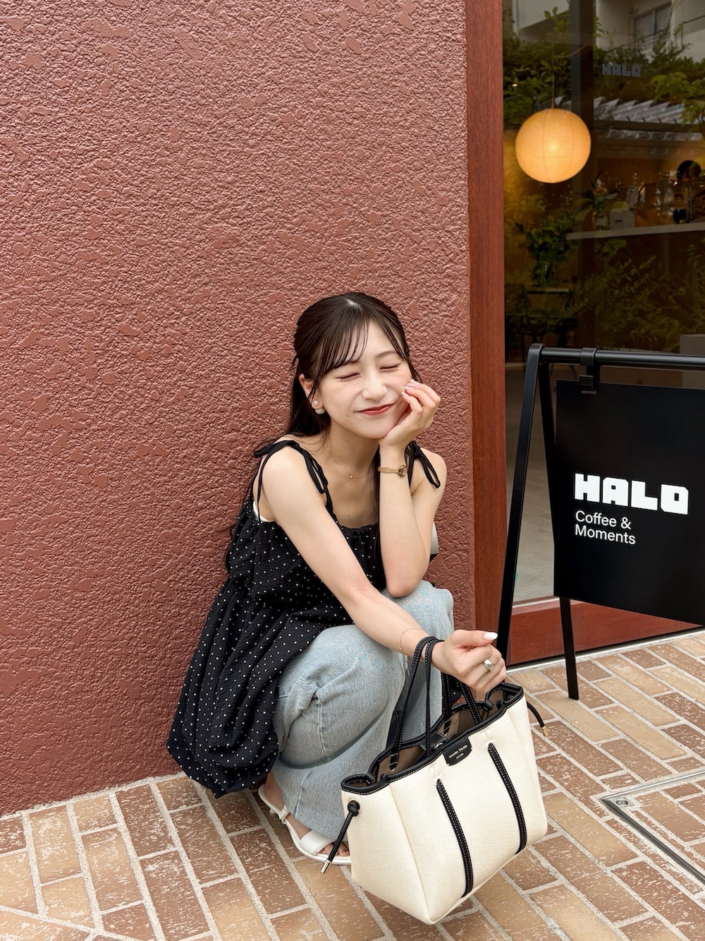 ホワイト系のサンダル、ホワイト系のトートバッグ、ブルー系のデニムパンツを着用したレディースの夏コーディネートの3枚目の写真
