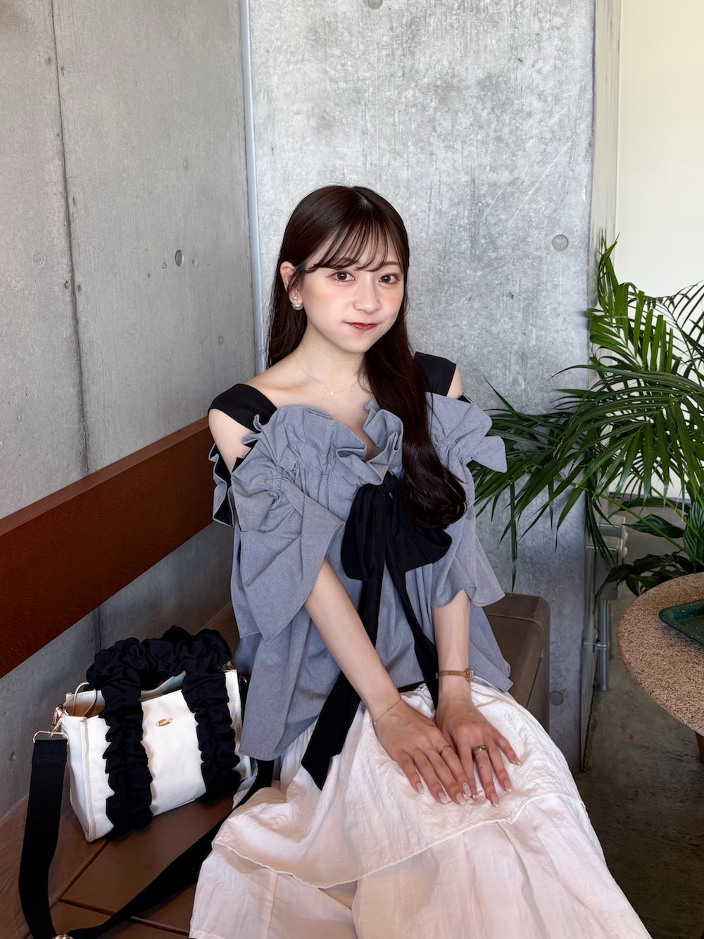 グレー系のシャツ/ブラウス、ブラック系のサンダル、ホワイト系のスカートを着用したレディースの夏コーディネートの3枚目の写真