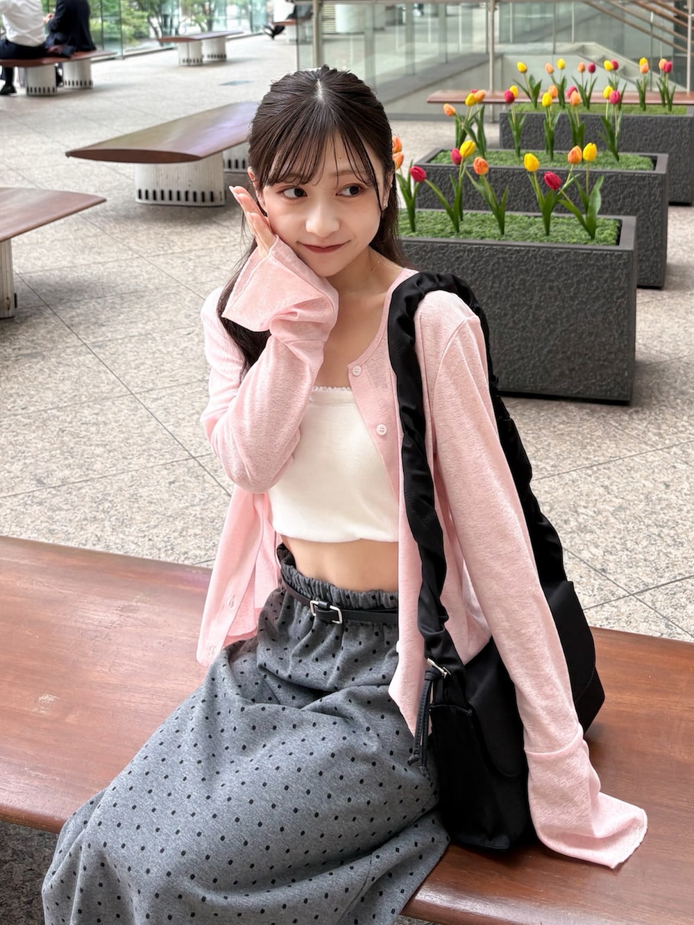 ブラック系のバッグ、ピンク系のカーディガン/ボレロ、ホワイト系のキャミソールを着用したレディースの夏コーディネートの4枚目の写真