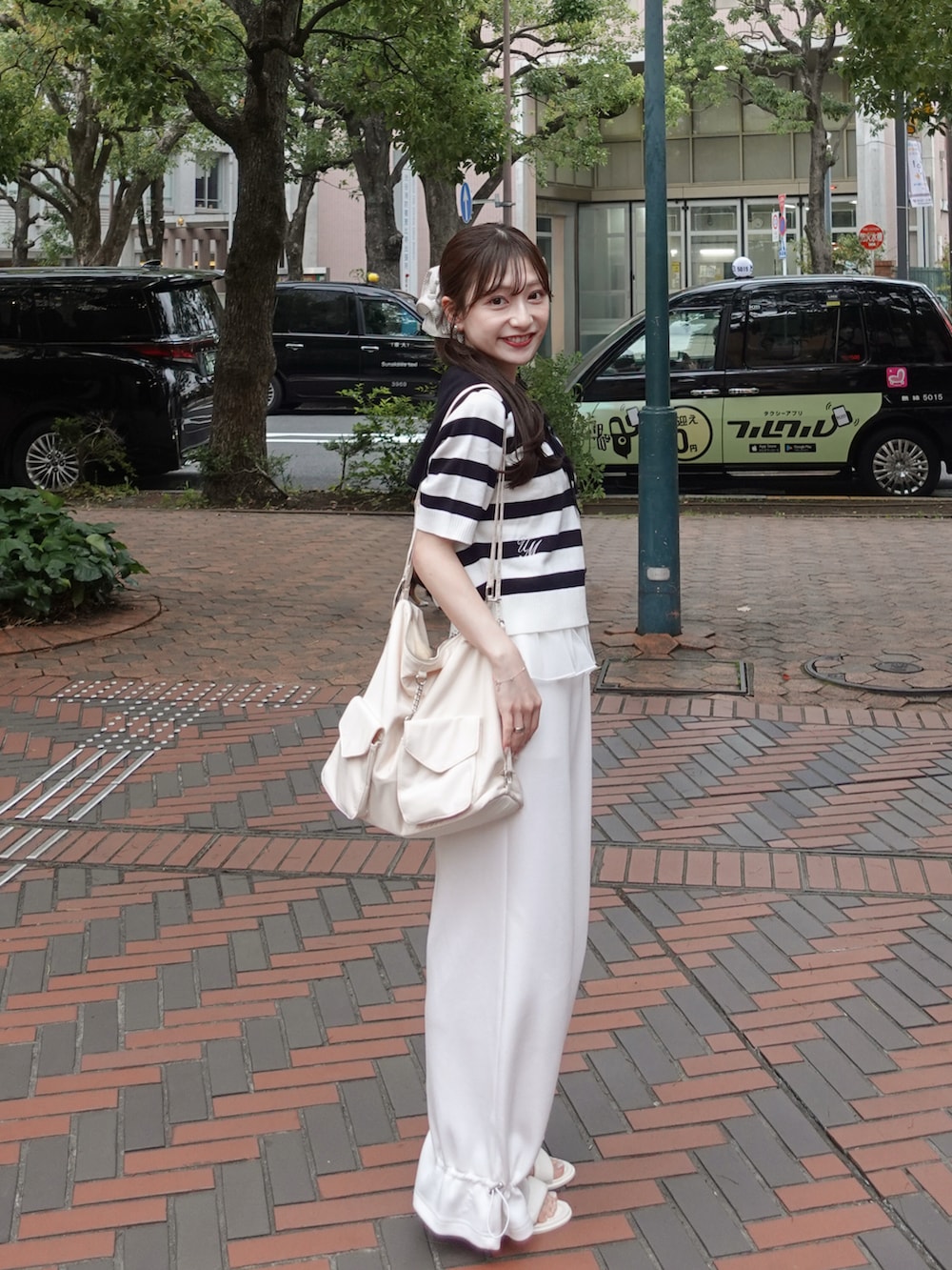 ホワイト系のスウェットパンツ、グレー系のニット/セーター、ホワイト系のトートバッグを着用したレディースの夏コーディネートの2枚目の写真
