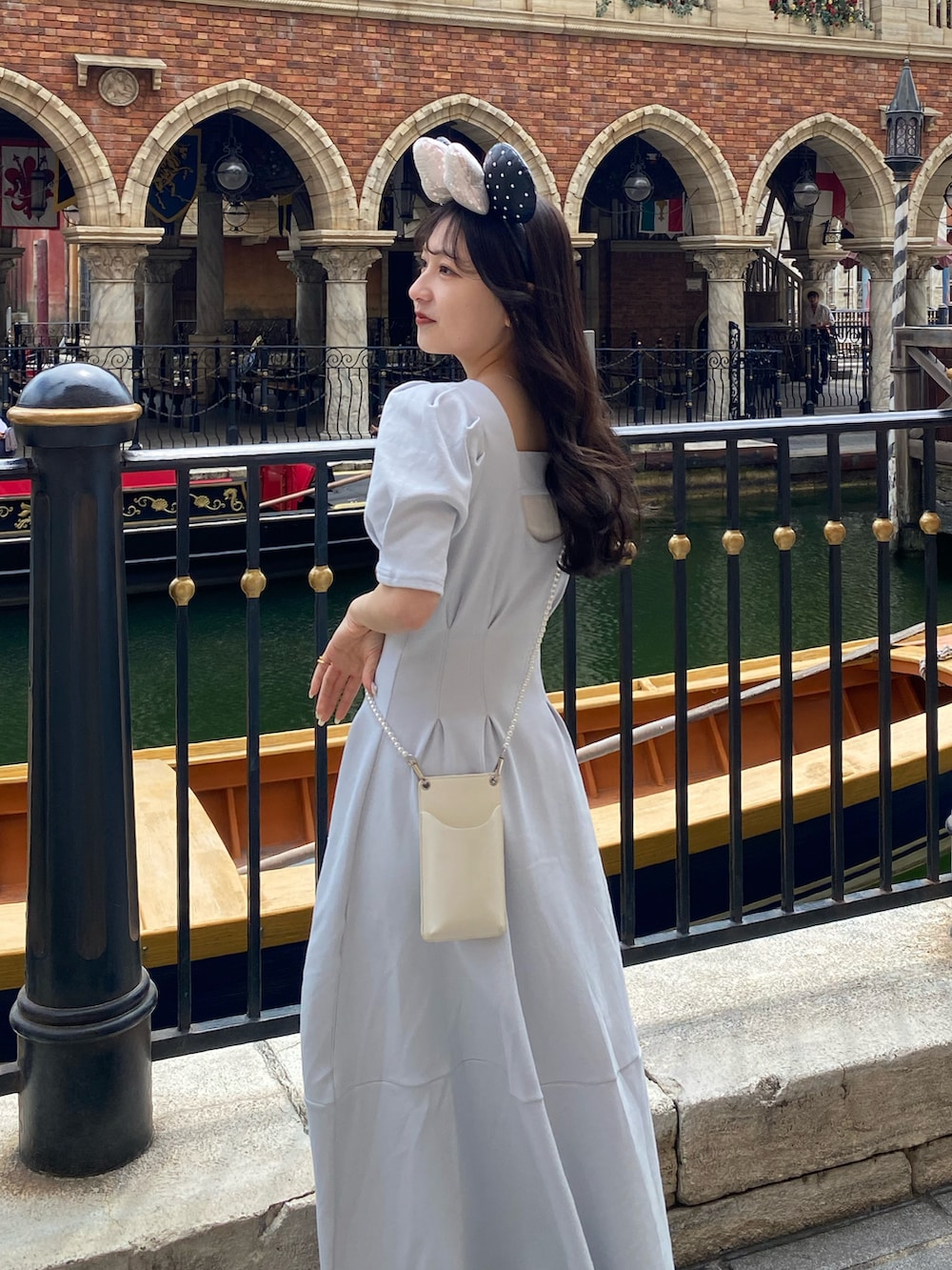 ホワイト系のショルダーバッグ、ホワイト系のシャツ/ブラウス、ブルー系のワンピースを着用したレディースの春コーディネートの3枚目の写真