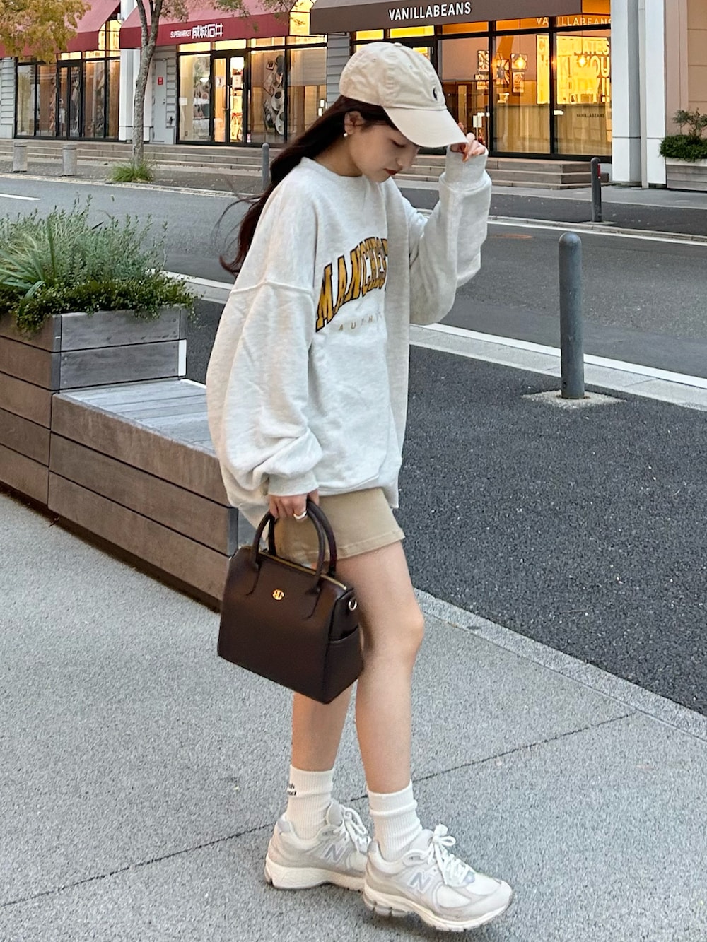 ベージュ系のデニムスカート、ベージュ系のスウェット、グレー系のスニーカーを着用したレディースの秋コーディネートの2枚目の写真