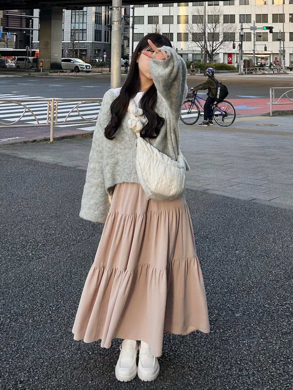 グレー系のカーディガン/ボレロ、ホワイト系のスカート、ホワイト系のトップスを着用したレディースの春コーディネートの4枚目の写真