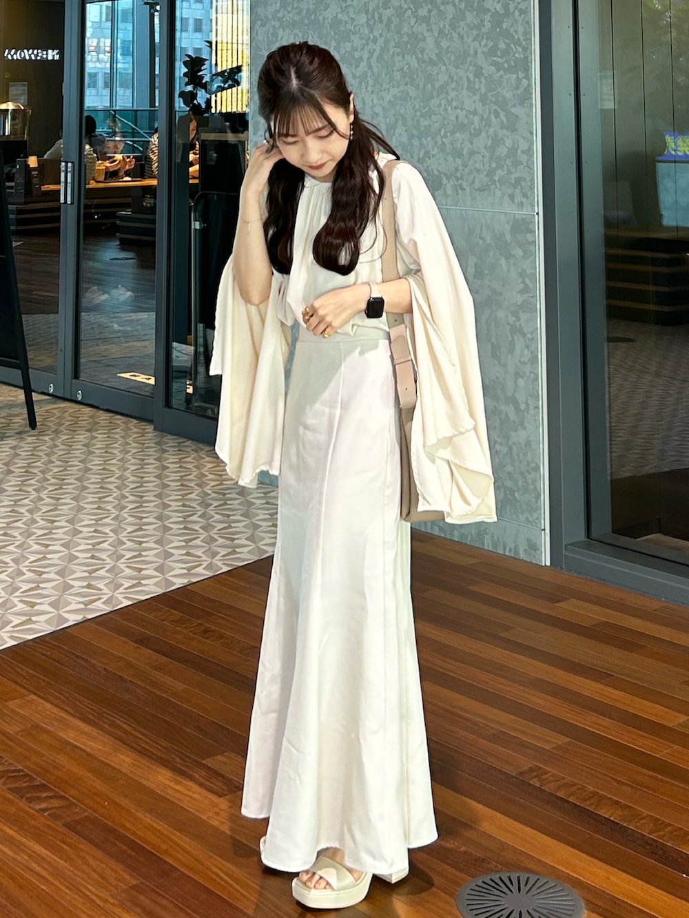 ホワイト系のスカート、ベージュ系のシャツ/ブラウス、ホワイト系のサンダルを着用したレディースの春コーディネートの3枚目の写真