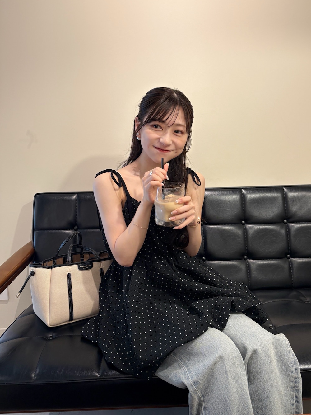 ホワイト系のサンダル、ホワイト系のトートバッグ、ブルー系のデニムパンツを着用したレディースの夏コーディネートの4枚目の写真