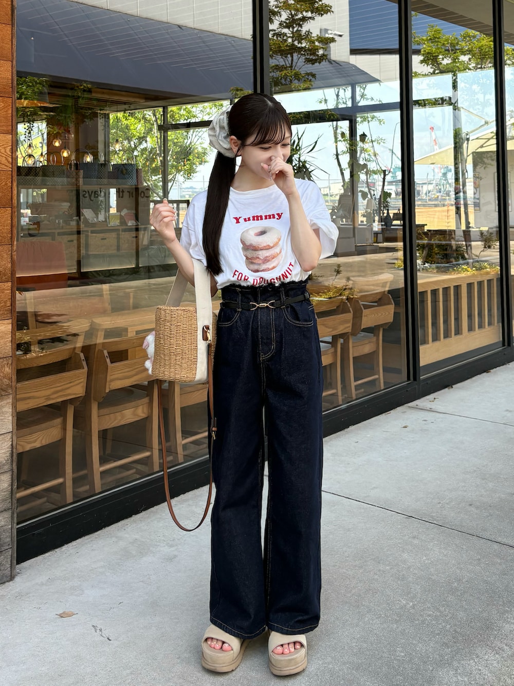 ブルー系のデニムパンツ、ホワイト系のTシャツ/カットソー、ベージュ系のサンダルを着用したレディースの夏コーディネートの3枚目の写真