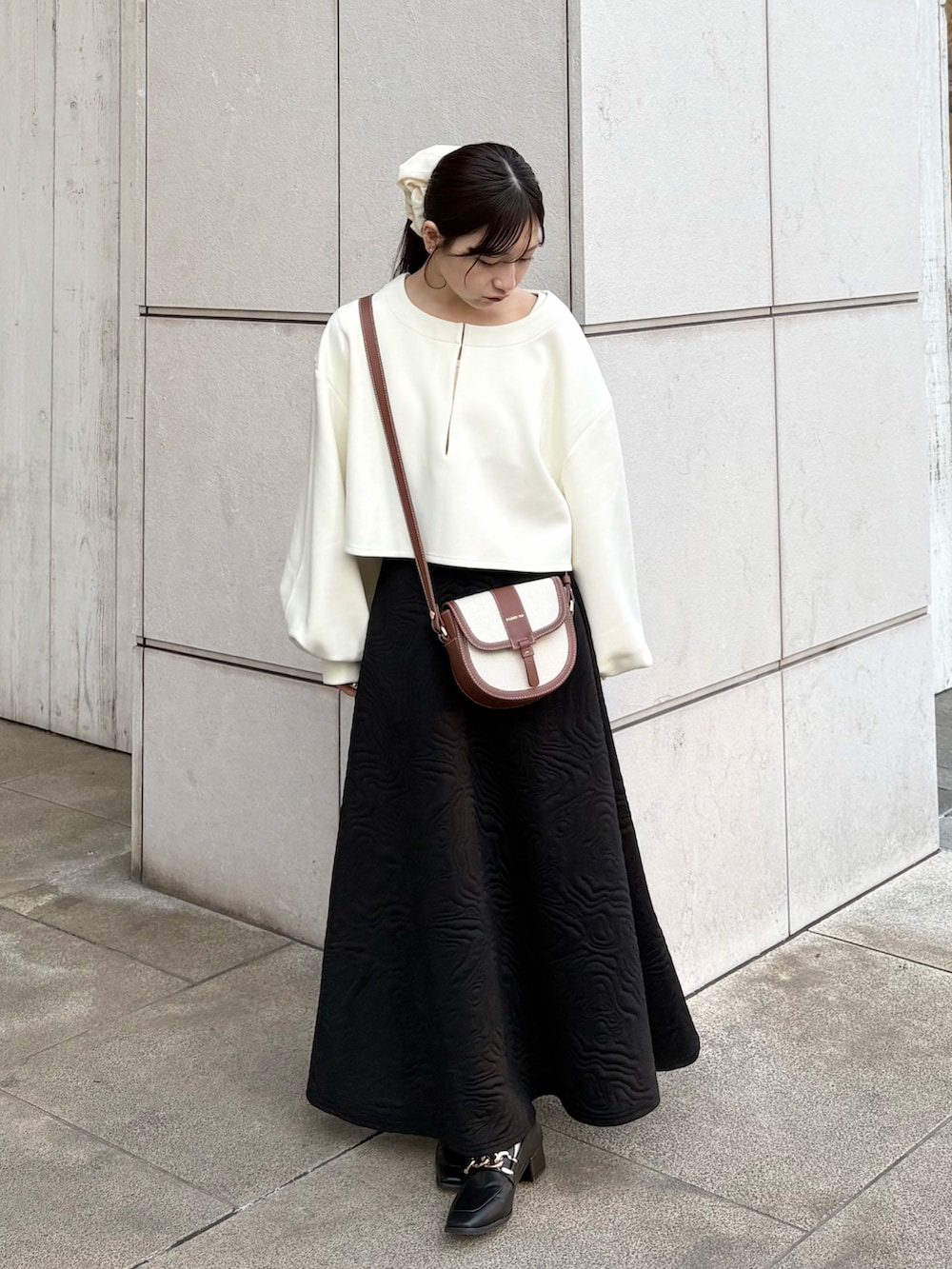 ホワイト系のワンピース、ブラック系のスカート、ブラック系のローファーを着用したレディースの春コーディネートの3枚目の写真